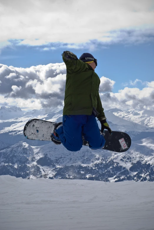 person jumping in air with a snowboard on snowy ground