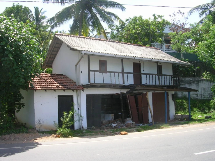 an old house with a large window and broken down shutters