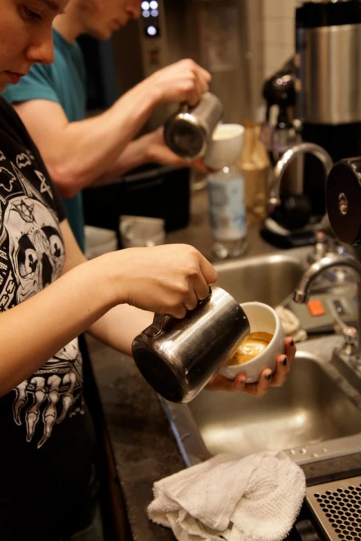 a woman is holding a coffee cup and stirring coffee