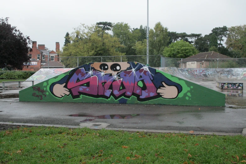 a skateboard park has a colorful graffiti - filled ramp