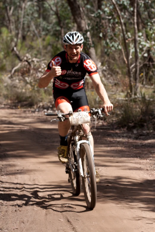 a bicyclist who is riding down a dirt path