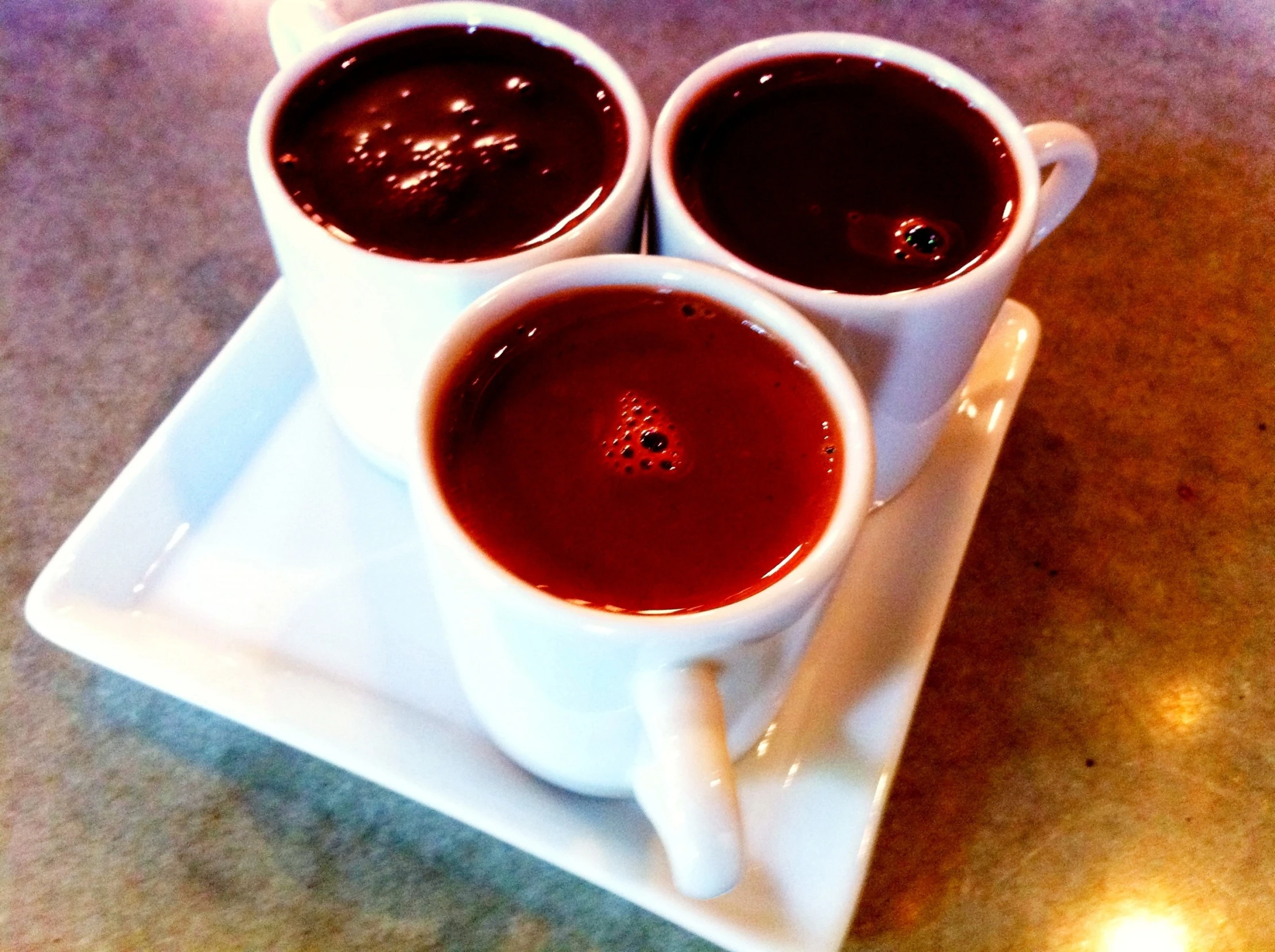 a trio of mugs filled with melted chocolate