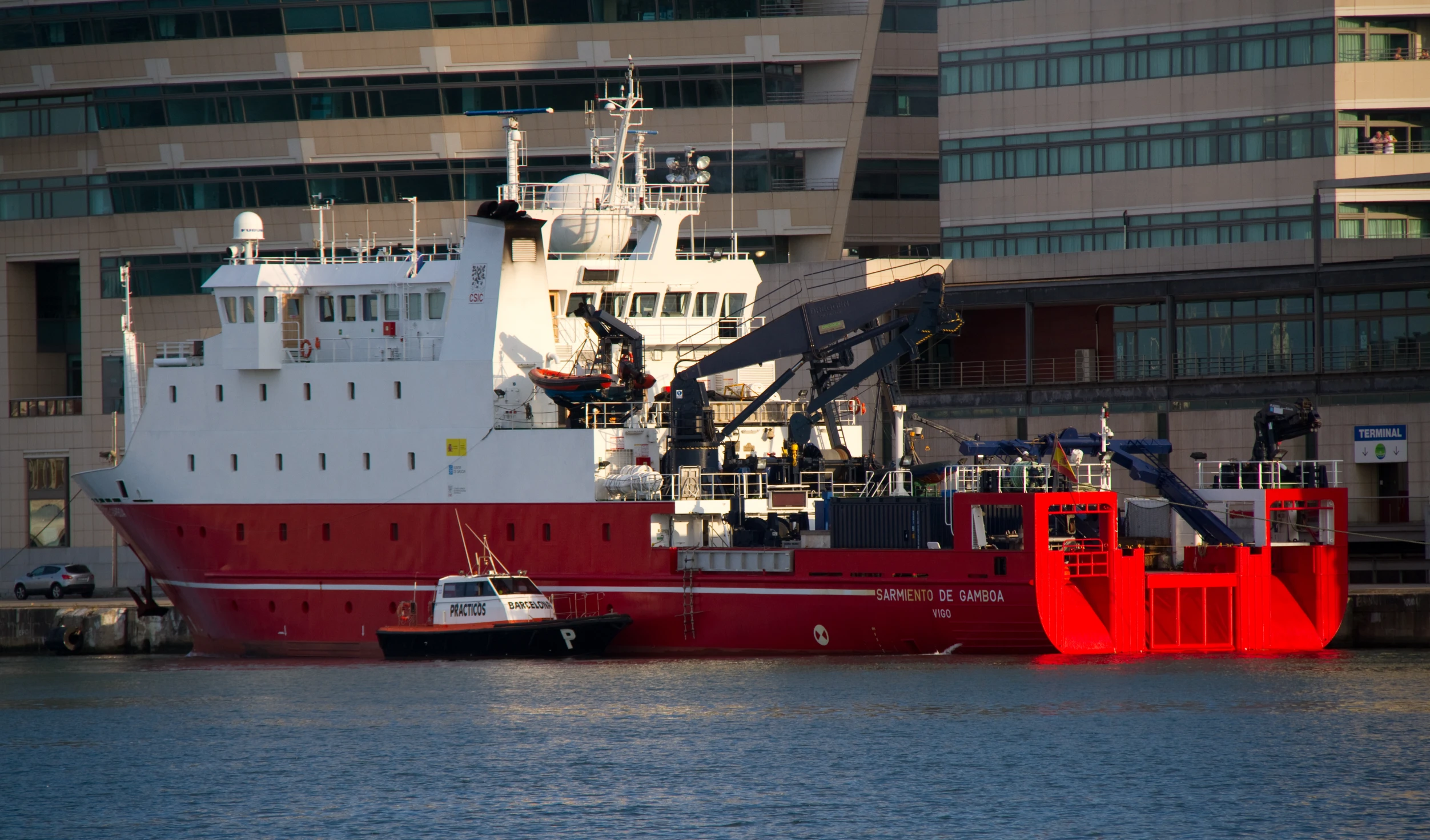 two boats in the dock by large buildings