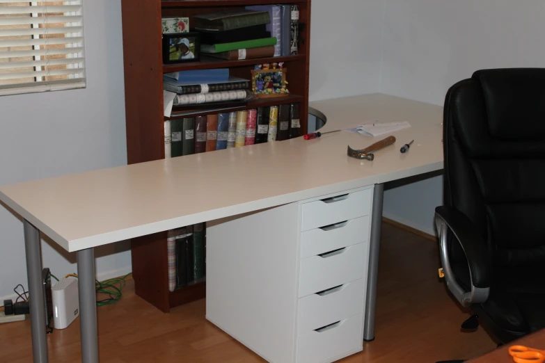 an office with a desk, chair, and shelves