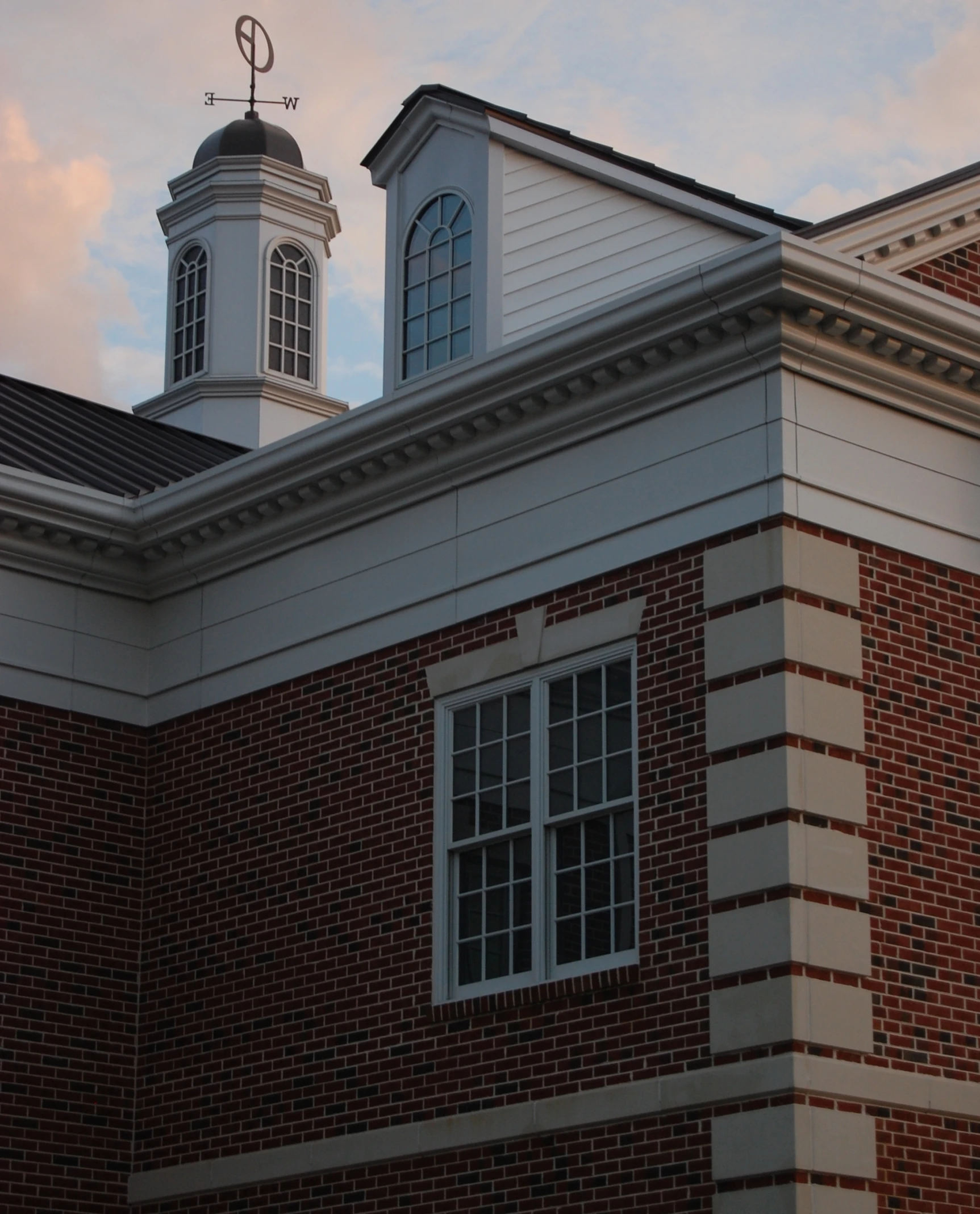 a brick building with a weather vane on the roof