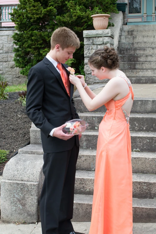 a boy and girl feeding each other donuts outside