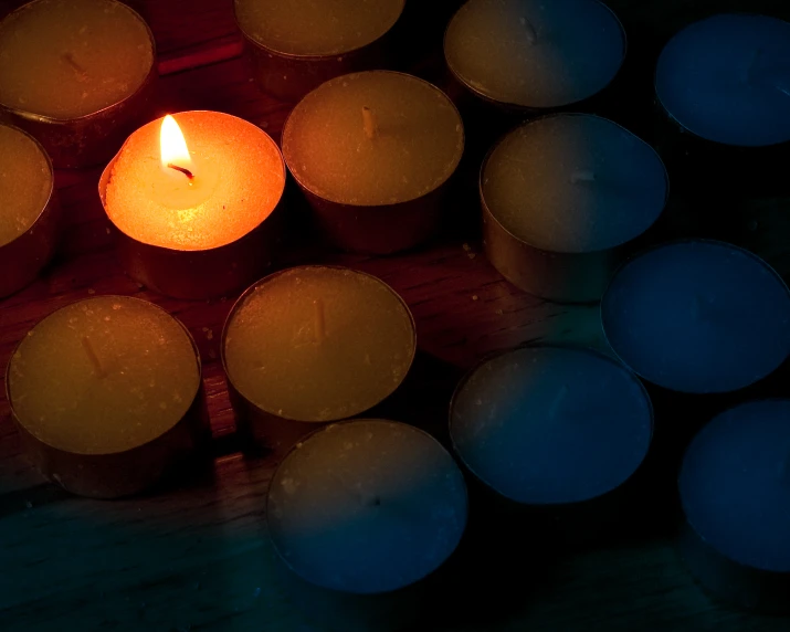 several lit tealights in a box, the candle has small candles and is blue in color