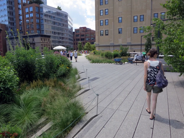 woman walking on boardwalk in urban area with highrise buildings