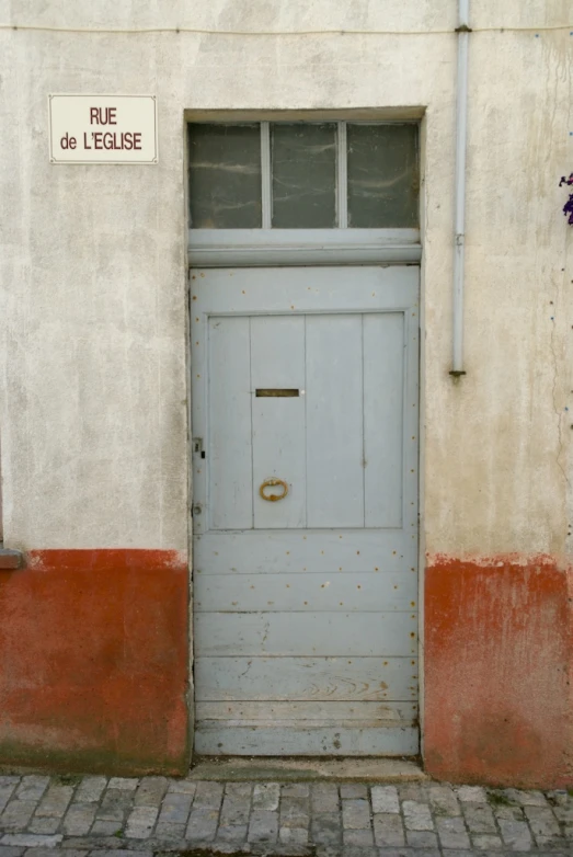 an open gray door next to a red brick sidewalk