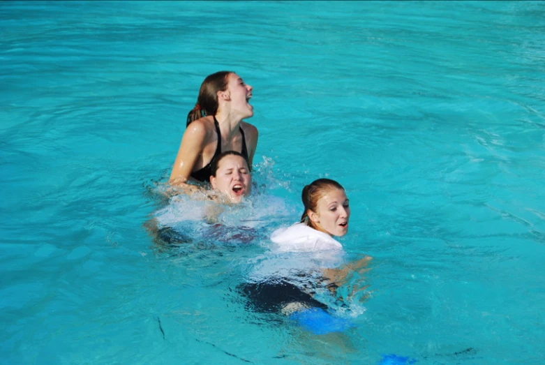 two girls who are playing in the pool