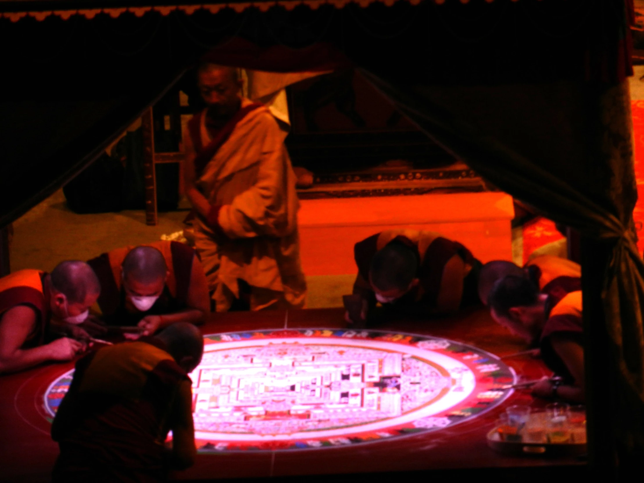 a group of men sitting around a table with a mosaic