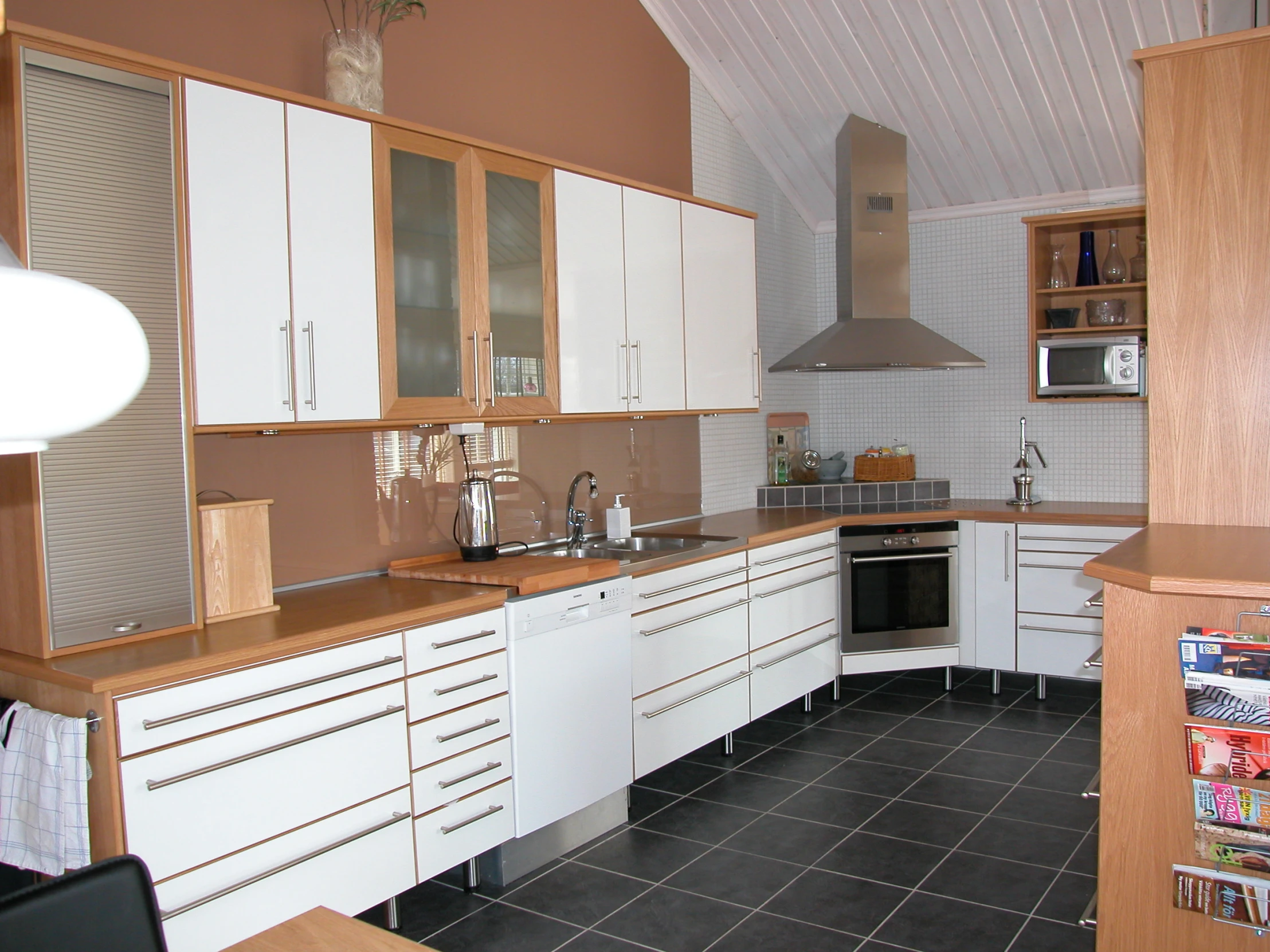 a kitchen with tile flooring, white cabinets and counters