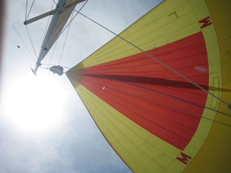 the bottom of a sail under the bright blue sky