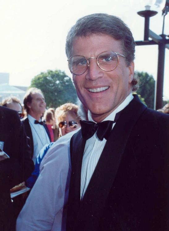 a man in suit and tie smiling at the camera