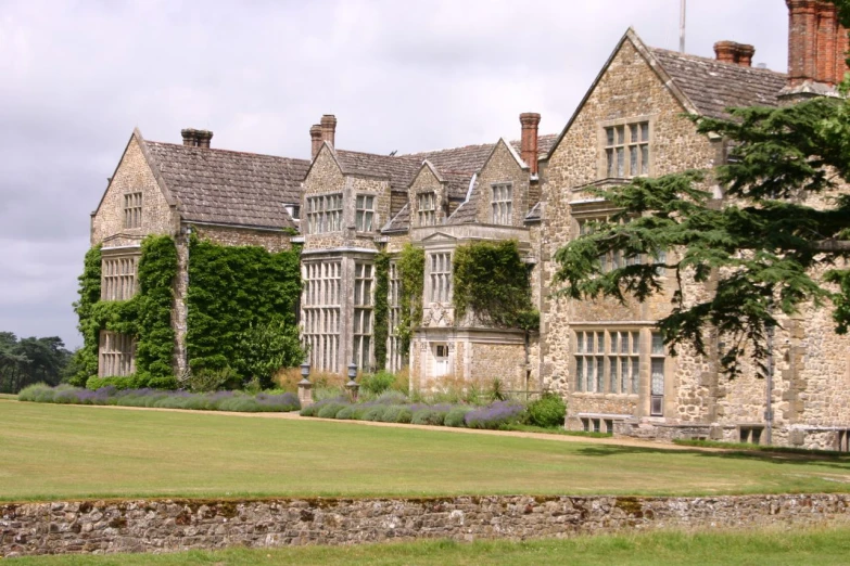 an old castle like house with trees and bushes near by