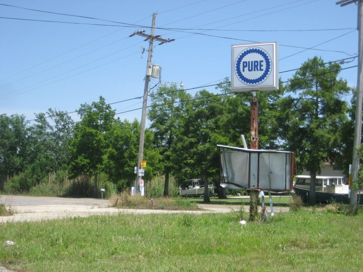 a pepsi sign next to a parking lot with trees in the background