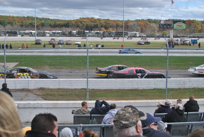 cars race around the track at an outdoor race track