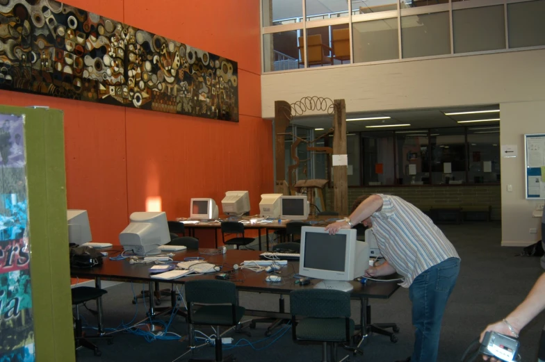 a woman holding her head behind an old desktop computer