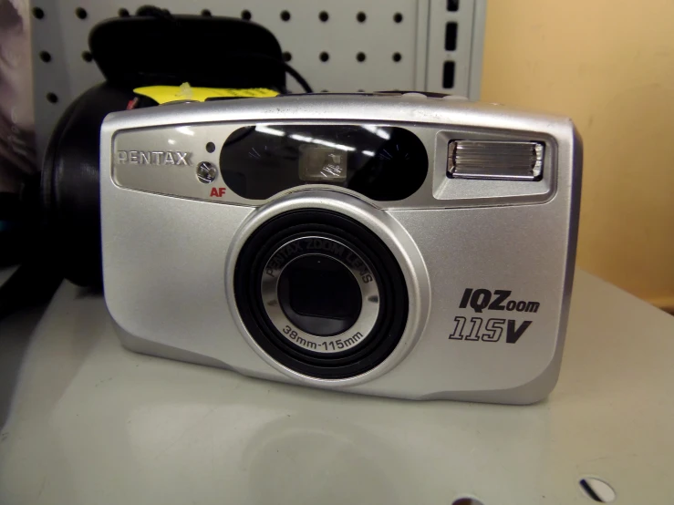 a silver digital camera sitting on a white table