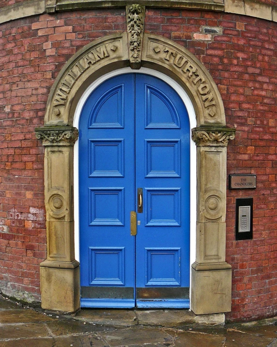 a double blue door is shown in a brick building