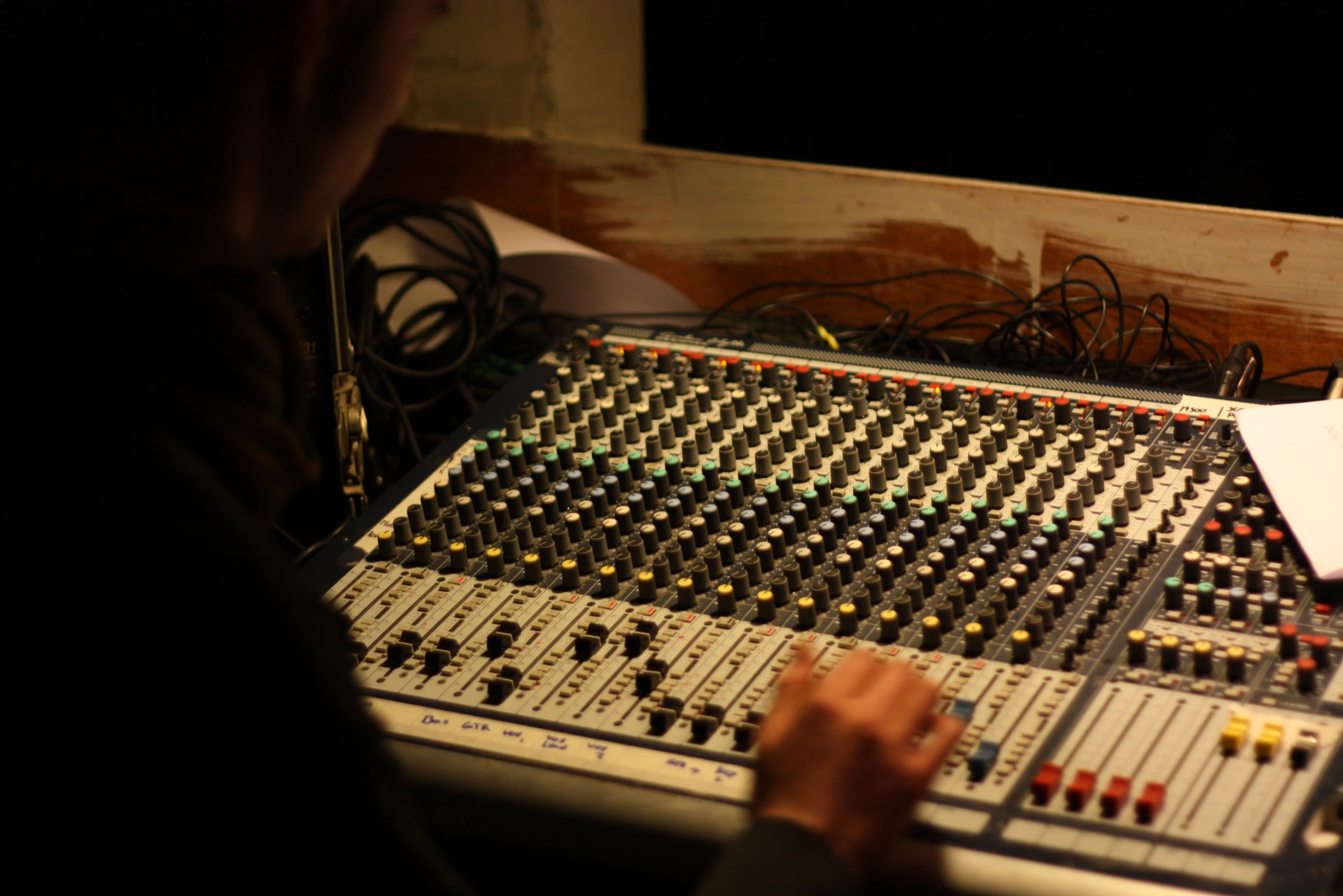 man behind sound board recording in music studio