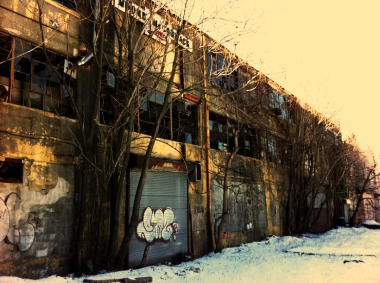 a large building with windows, a clock and graffiti