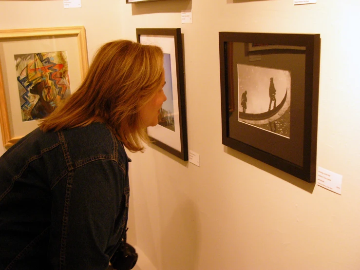 woman looking at artwork in museum exhibit on wall