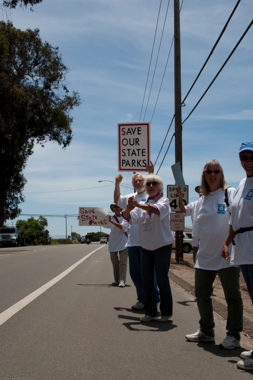 people in white shirts are marching down the street