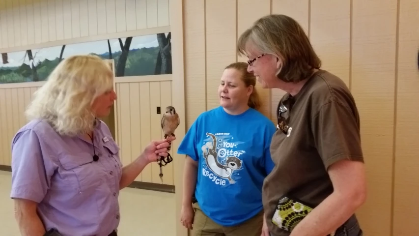 the woman in blue is talking to two other people