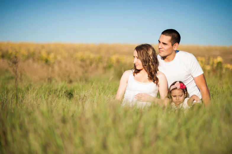 a man and woman stand near two s in tall grass