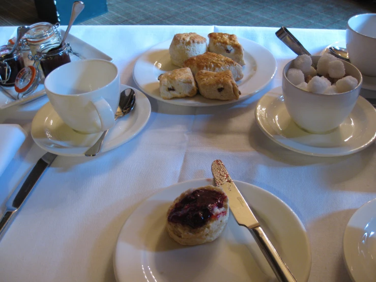 a table topped with white plates filled with pastries