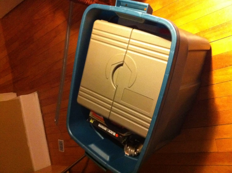 a large blue container with tools inside sits on the floor