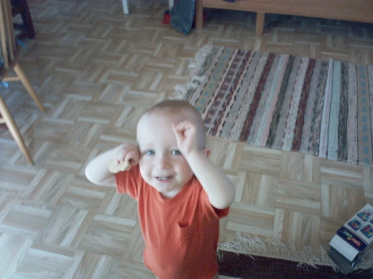 a boy holding his head in his hand and smiling