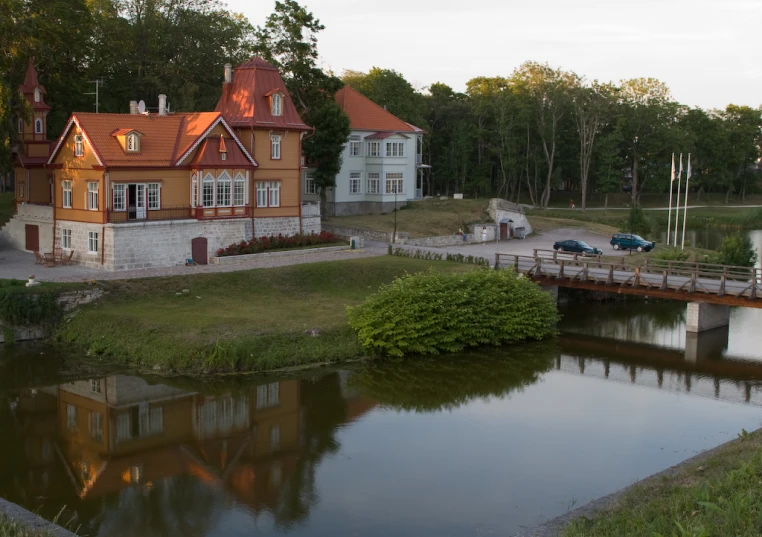 a house beside the water with a red roof