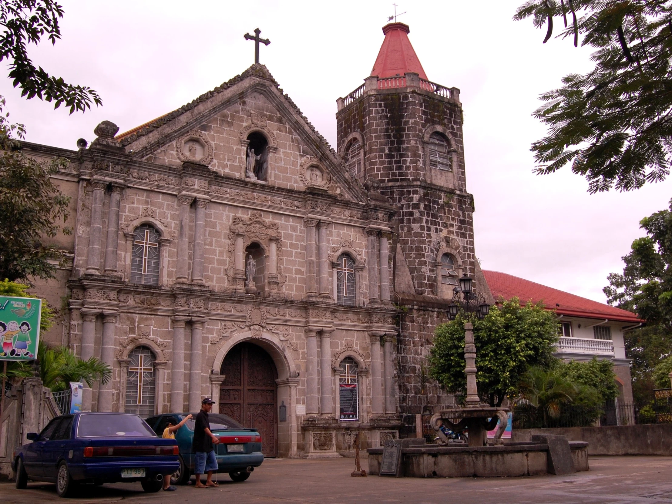 two cars are parked in front of an old church