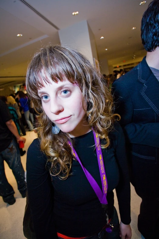 woman standing with a purple badge around her neck