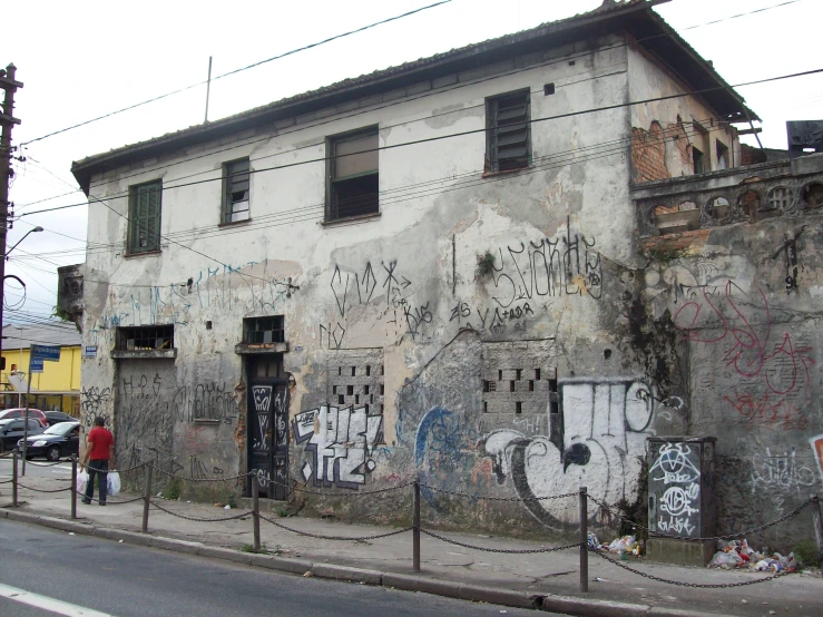 an old building with graffiti is along a street