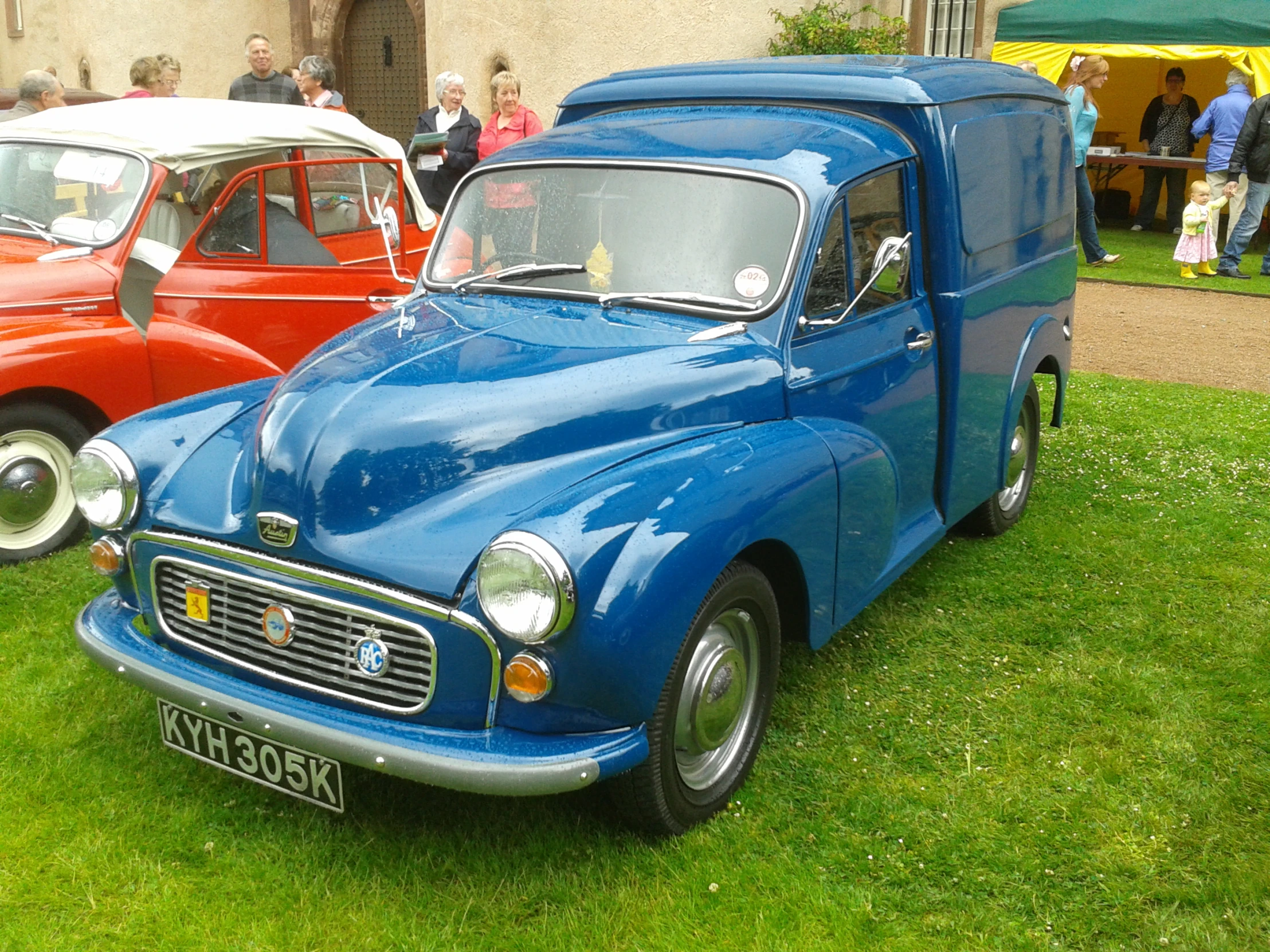 a blue truck and another red car in the grass