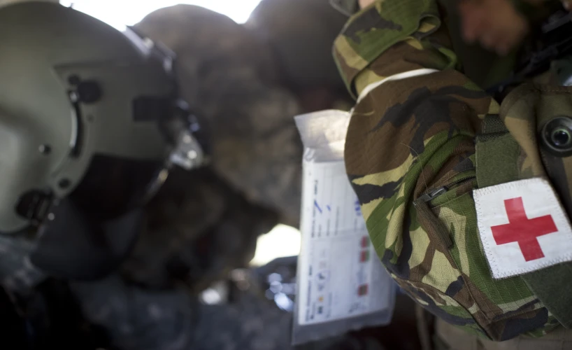 two army men with helmets and red cross patches