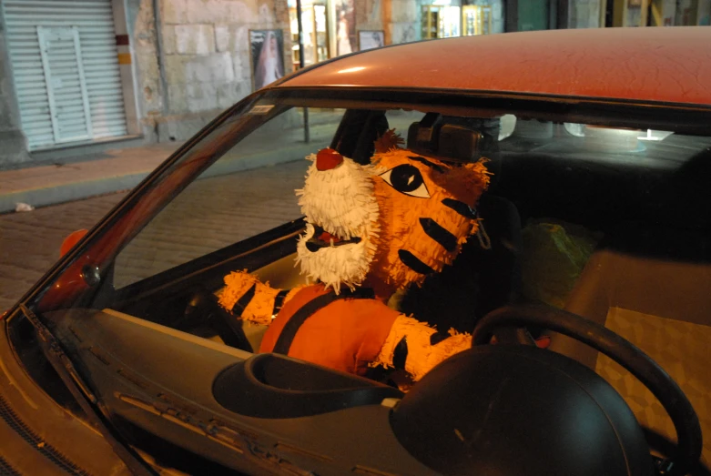 stuffed animal in the drivers seat of a car