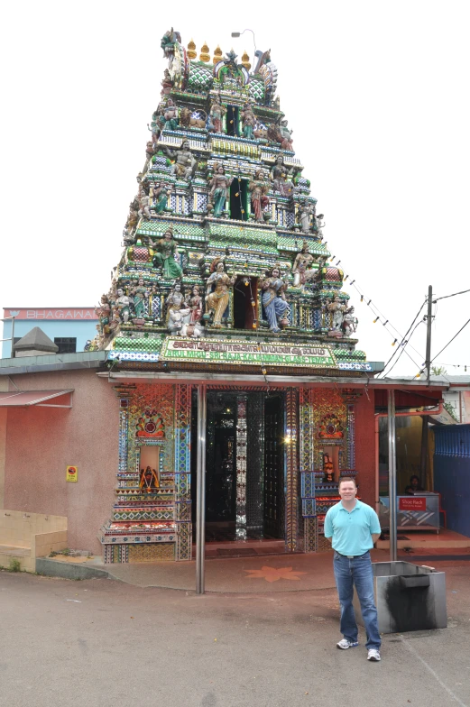 the man is posing in front of a tall structure