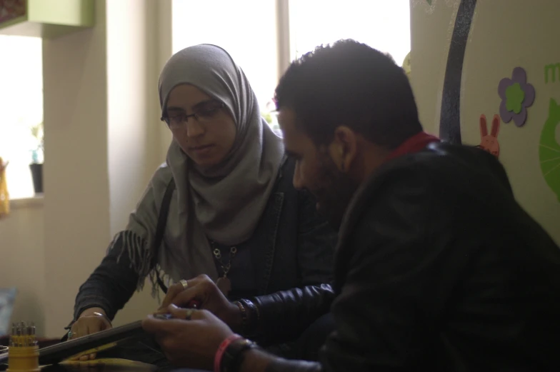 two people sitting at a table with drinks