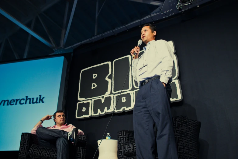 a man on stage at an event speaking