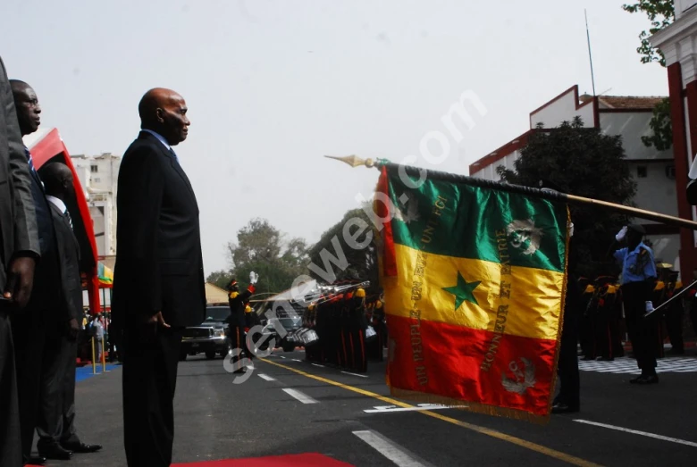 men in suits and ties standing in front of a flag