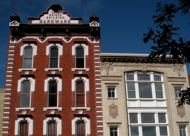 the front and side of two buildings with windows on a street