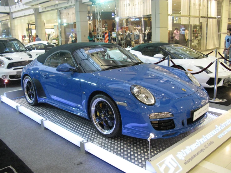 the blue sports car is on display at an automobile show