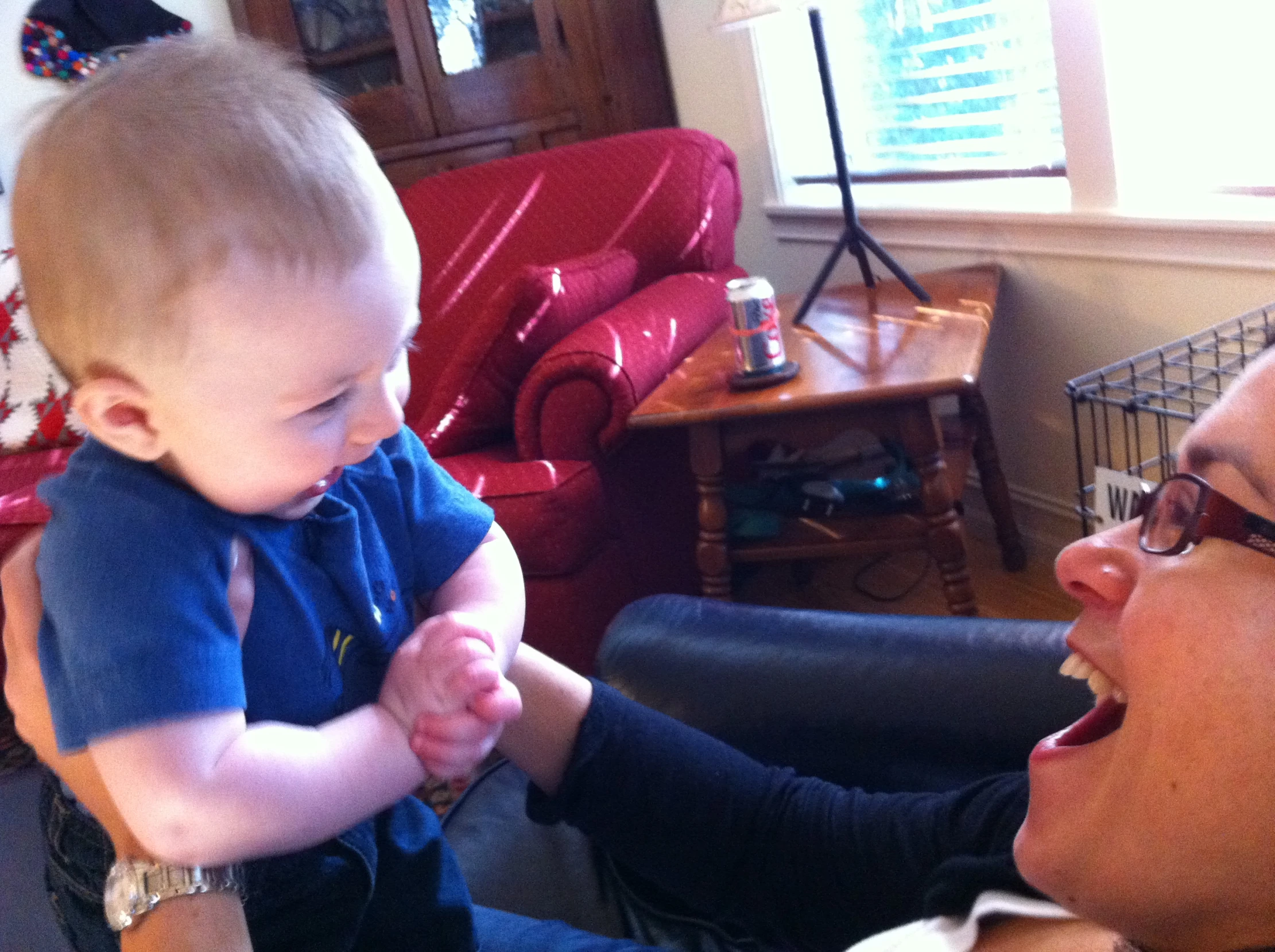 a baby sitting in a lady's lap while the woman is holding it up