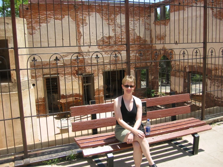 a young woman sitting on top of a wooden bench