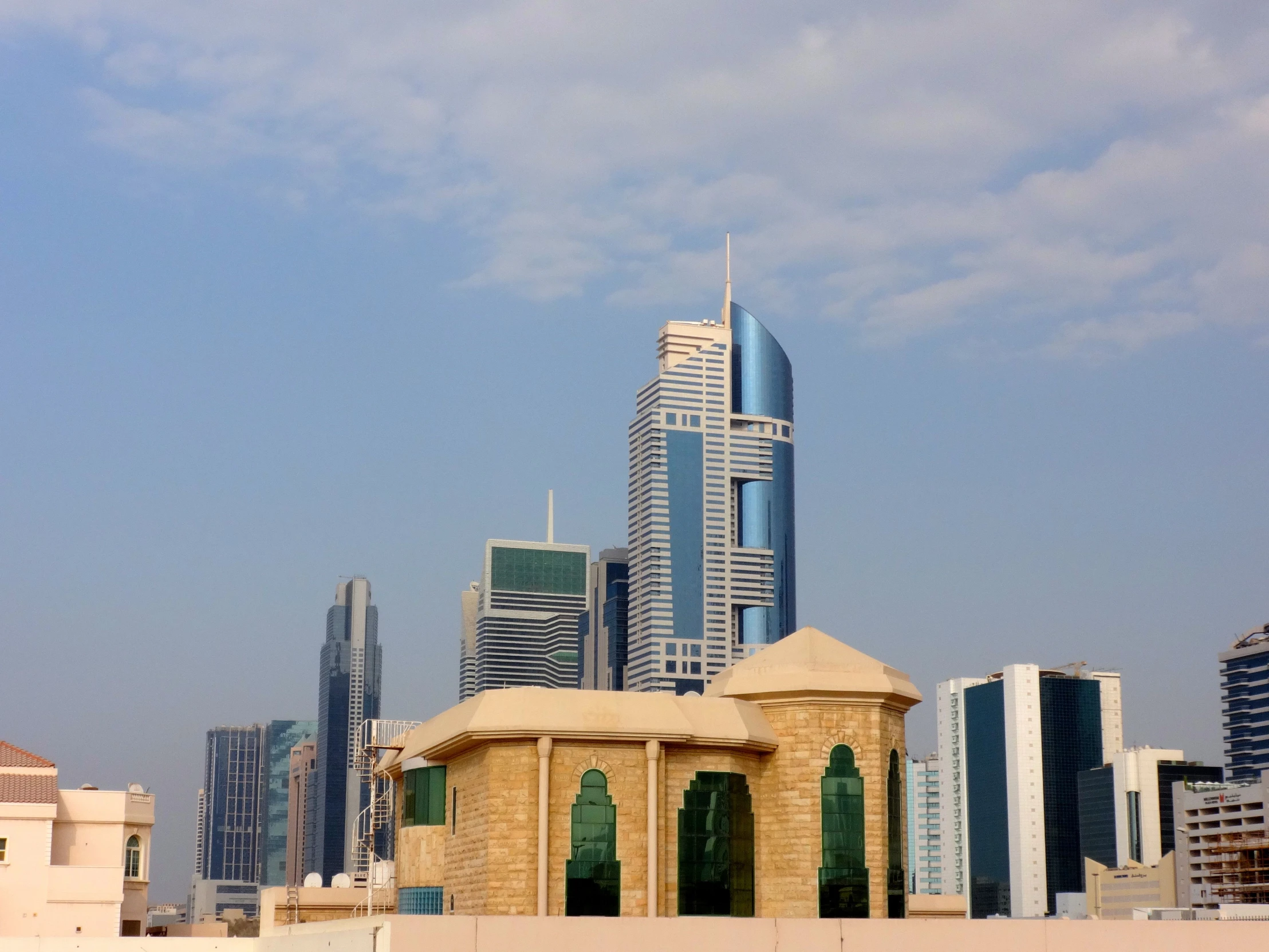 a city with a tall, yellow building sitting near some blue buildings