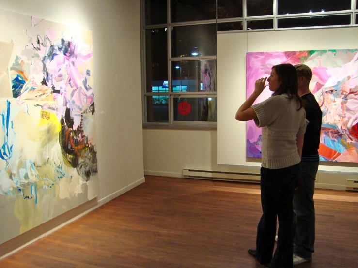 two women viewing paintings in an art gallery